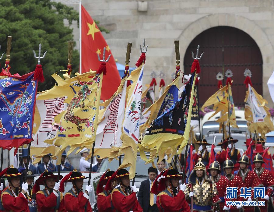 7月3日，韓國(guó)總統(tǒng)樸槿惠在青瓦臺(tái)總統(tǒng)府舉行隆重儀式，歡迎中國(guó)國(guó)家主席習(xí)近平對(duì)韓國(guó)進(jìn)行國(guó)事訪問(wèn)。這是習(xí)近平的車(chē)隊(duì)在身著民族服裝的韓國(guó)禮儀隊(duì)伍引導(dǎo)下駛?cè)肭嗤吲_(tái)。新華社記者丁林?jǐn)z  